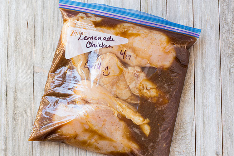 Grilled Lemonade Chicken Freezer Meal prepared in a ziptop freezer bag and laying on counter.