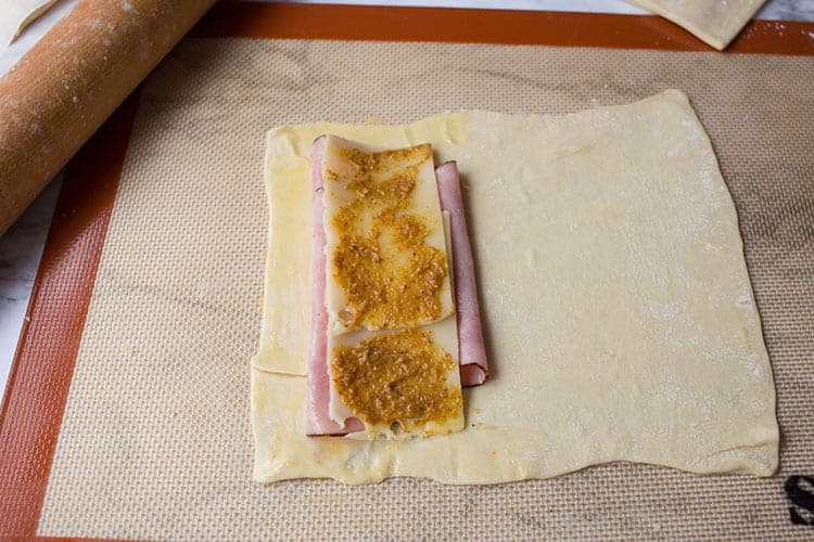 Overhead shot showing how to assemble homemade ham and cheese hot pockets prior to freezing.