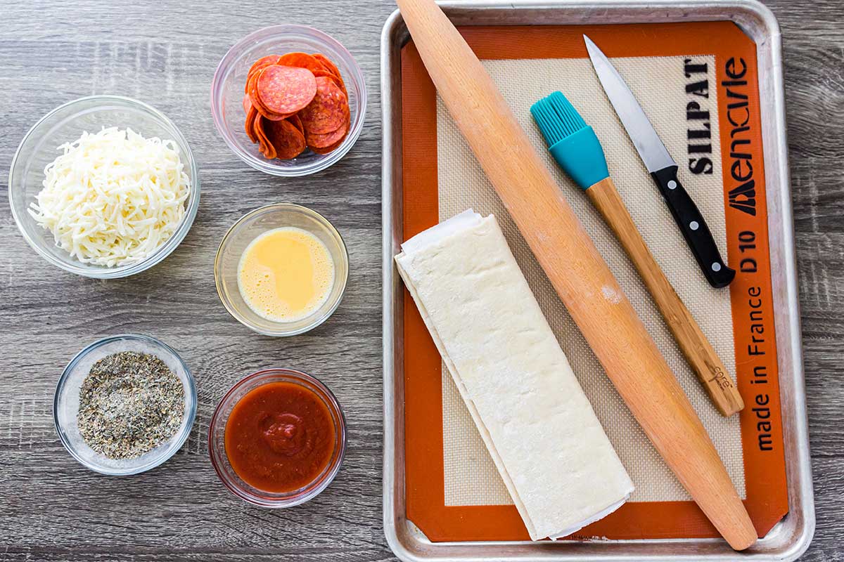 Overhead shot of ingredients & equipment for making pizza pockets.
