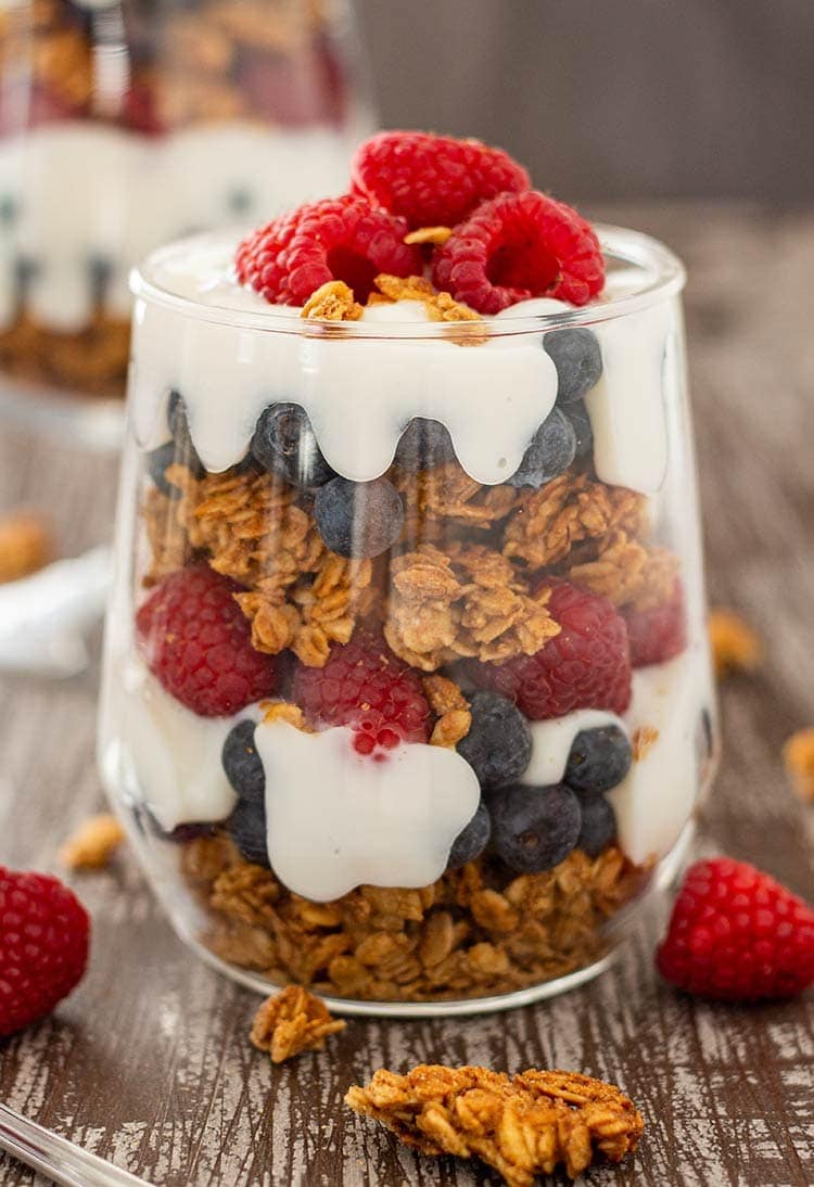 Easy Granola Parfait in cup, layered with blueberries, raspberries and yogurt.