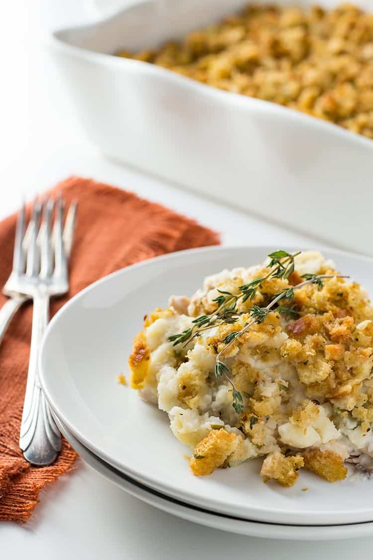 Thanksgiving Casserole dished up on a plate with casserole dish behind it