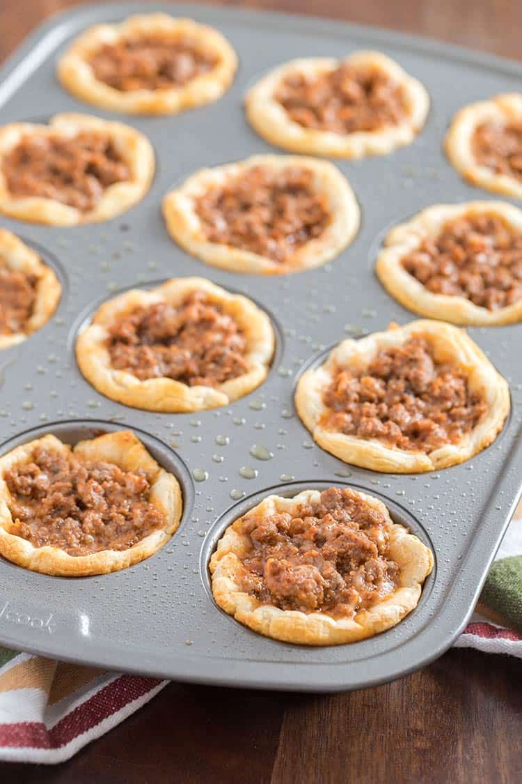 Savory Italian Biscuit Cups in muffin tin after baking but before final layer of cheese