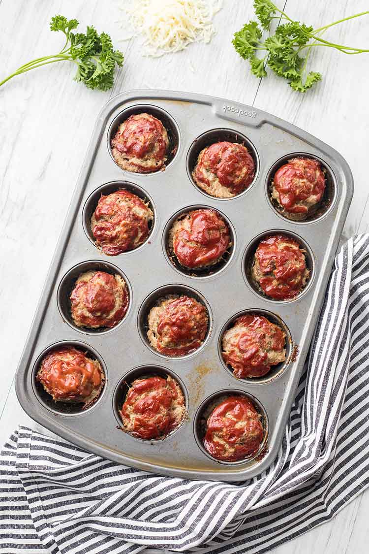 An overhead shot of a muffin tin full of cooked Mini Mozzarella Meatloaf Muffins
