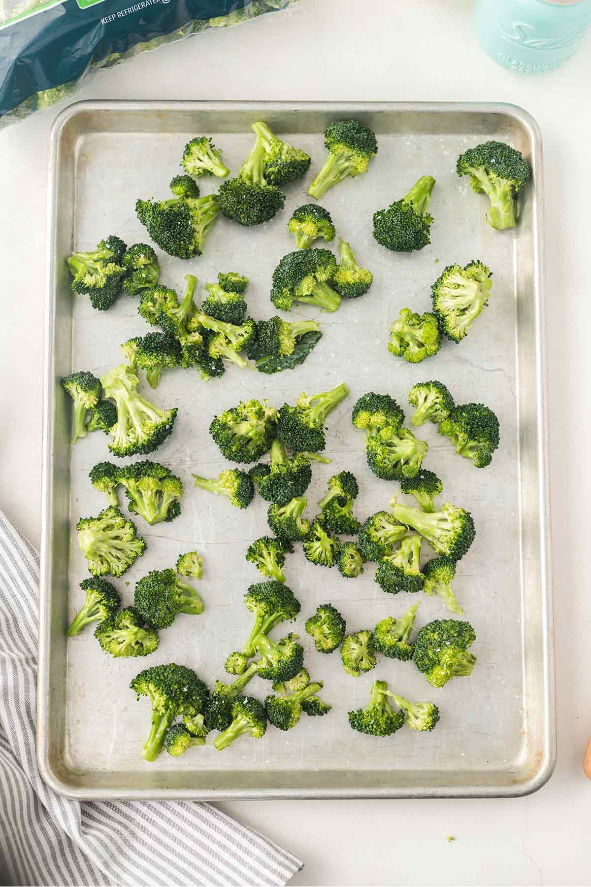 Overhead shot of broccoli florets on baking sheet ready to go into the oven for roasting.