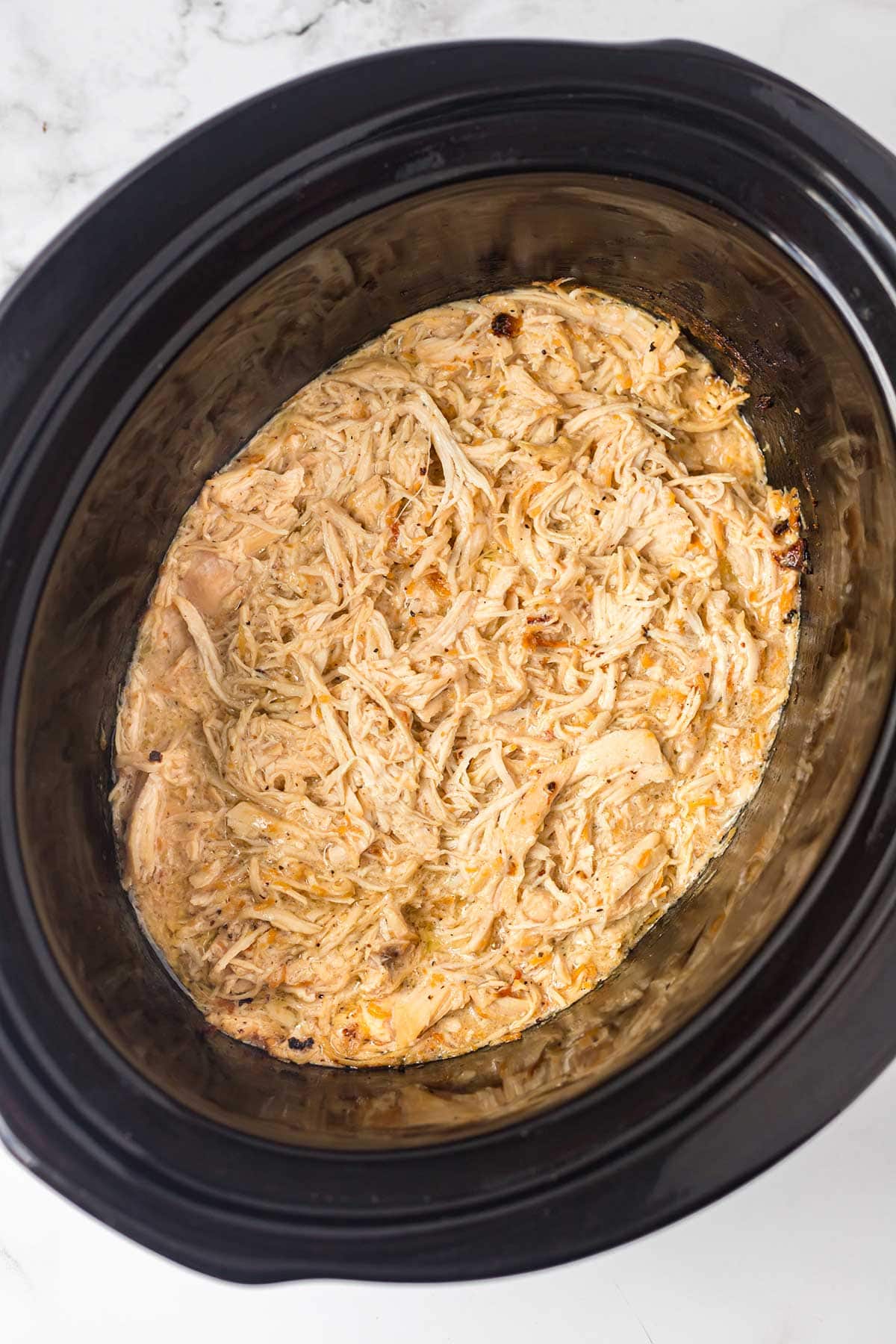 Caesar Chicken freezer meal being cooked in a slow cooker.